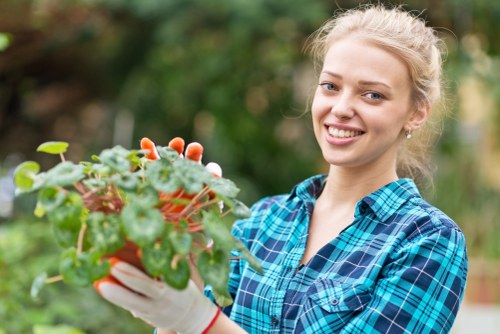 Gardener assessing a residential front garden with tools